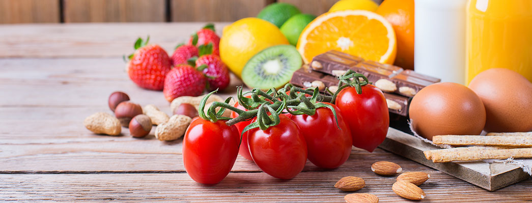 Tisch mit Tomaten, Nüssen, Erdbeeren und anderen Lebensmitteln