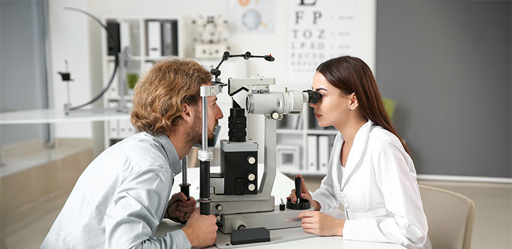 Mann bei Augenuntersuchung durch eine Augenärztin
