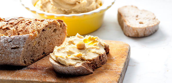 Brotscheibe mit Kichererbsenaufstrich und Kichererbse