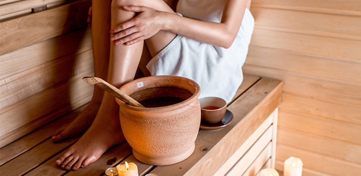 Frau sitzt auf einer hölzernen Saunabank