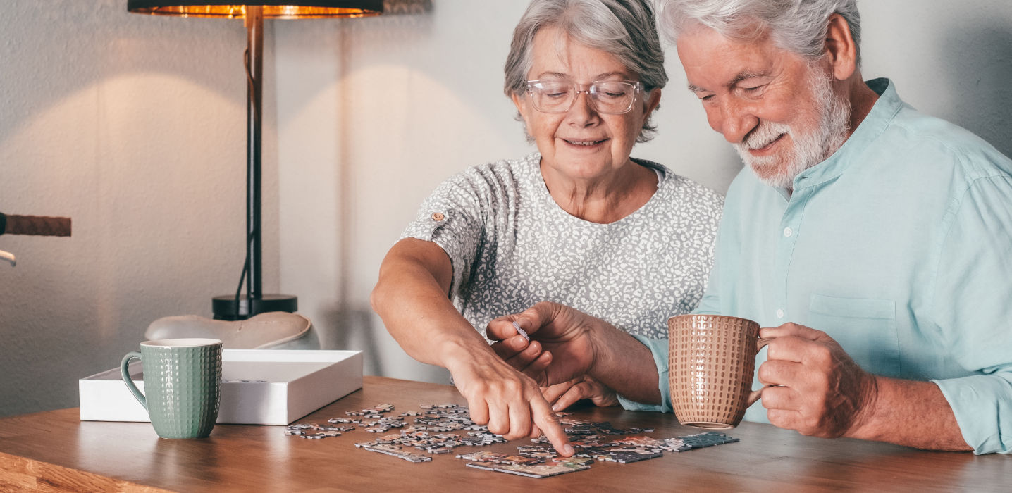 Altes Ehepaar bei einem Puzzle-Spiel