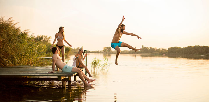 Gruppe von Freunden auf einem Steg am Badesee