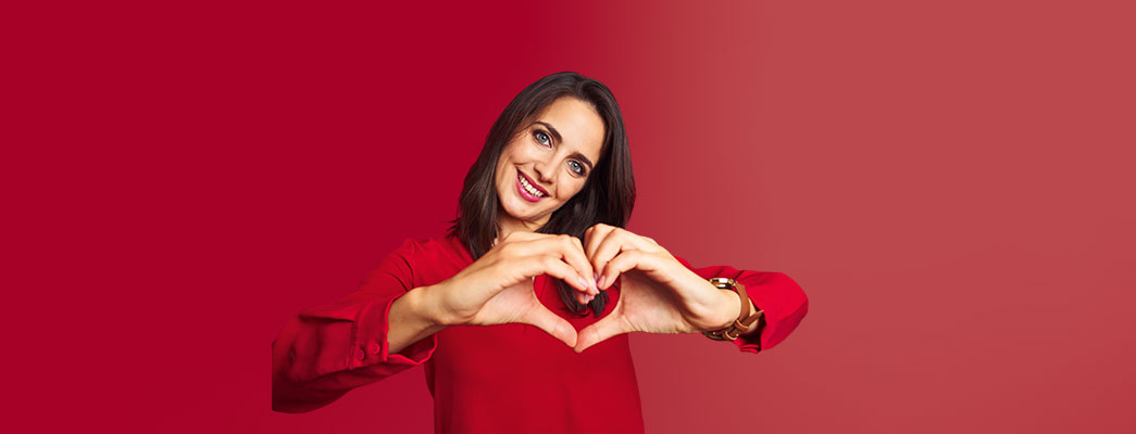 Frau die mit Händen ein Herz formt