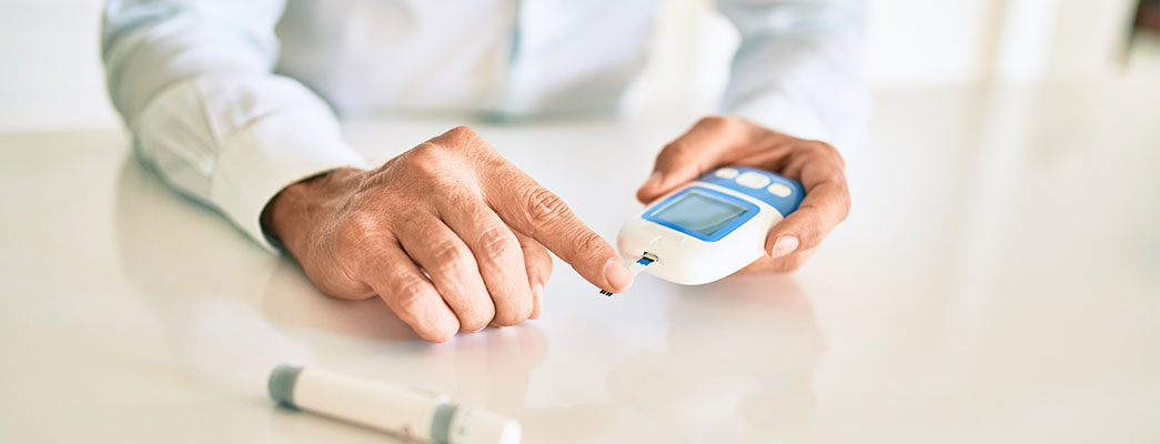 Apotheker führt die Funktionsweise eines Blutzucker-Messgeräts vor