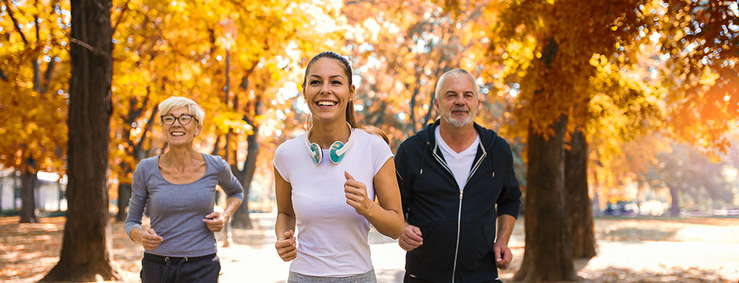 Junge Frau und älteres Paar beim Joggen
