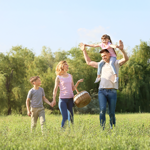 Familie spaziert glücklich durchs Gras