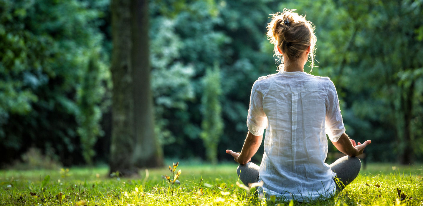 Junge Frau macht Yoga im Schneidersitz