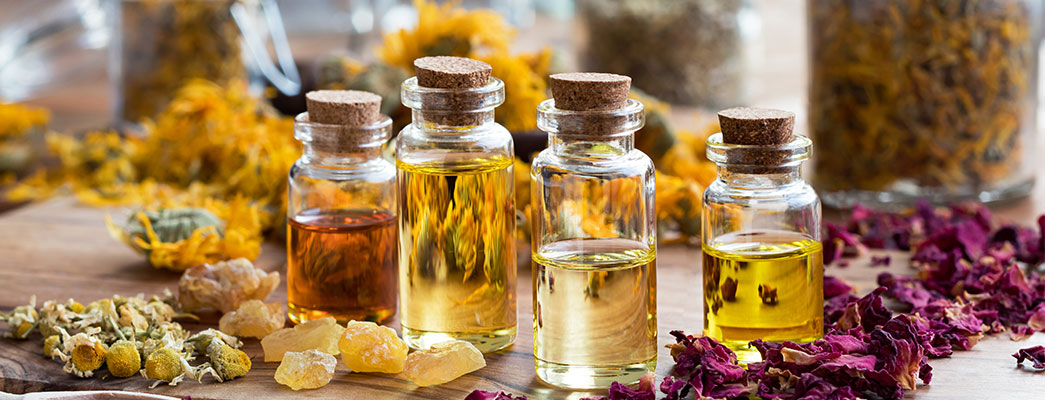 Kleine Glasfläschchen mit Korken zwischen Blütenblättern