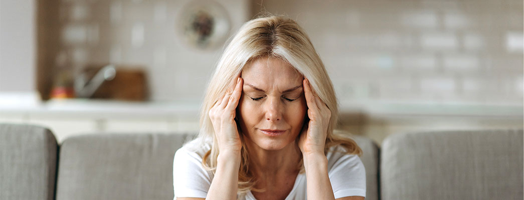 Frau die sich die Schläfen hält