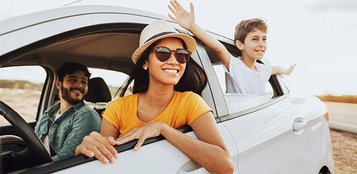 Vater, Mutter und Sohn sitzen in einem weißen Auto