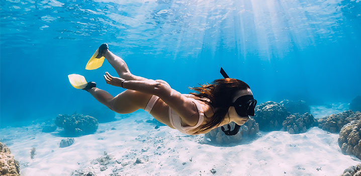 Junge Frau beim Schnorcheln im seichten Gewässer