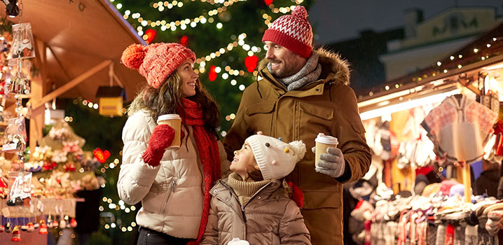 Vater, Mutter und Kind stehen auf dem Weihnachtsmarkt