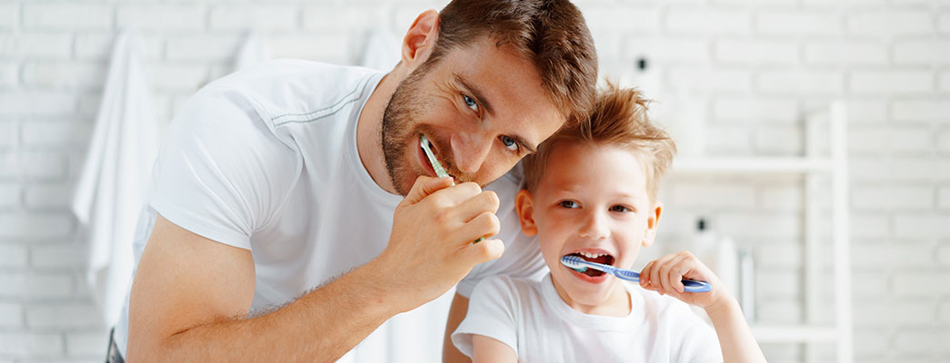 Vater und Sohn putzen gemeinsam Zähne