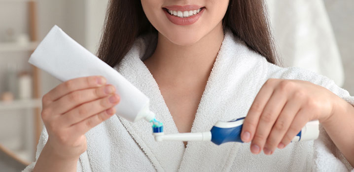 Frau steht in der Küche und schneidet Obst und Gemüse