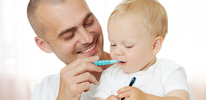Vater putzt Baby die Zähne